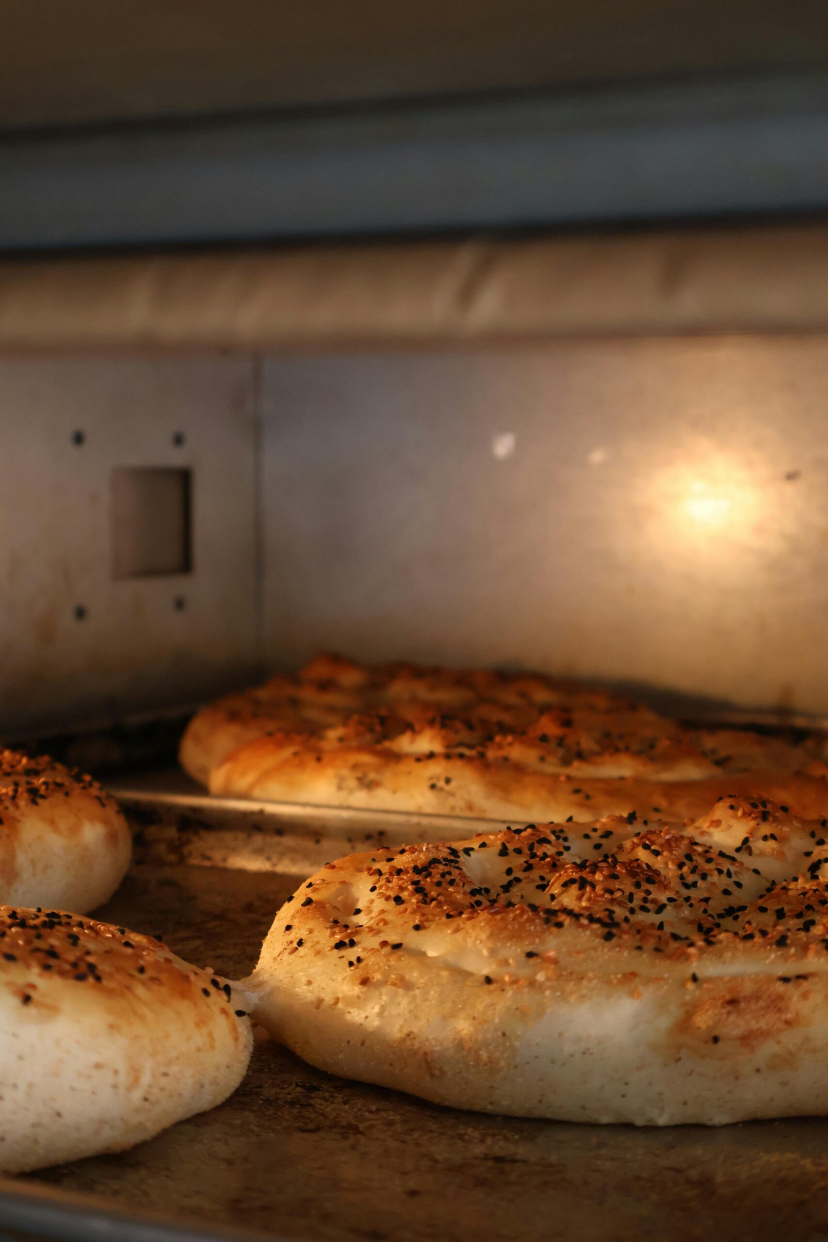 Delicious freshly baked sesame seed bread in a warm oven setting.